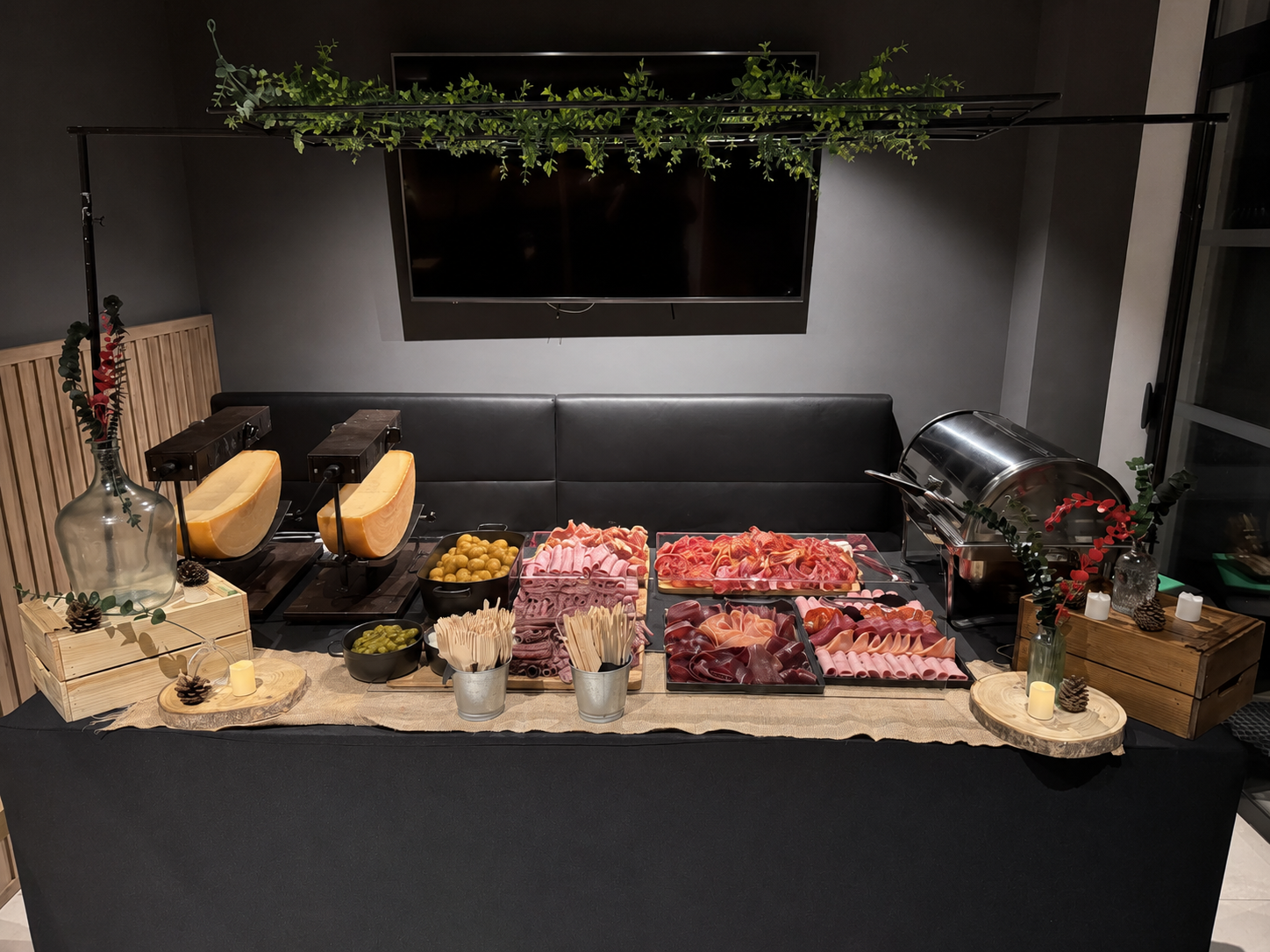 Buffet raclette à la demi-meule avec charcuteries et pommes de terre